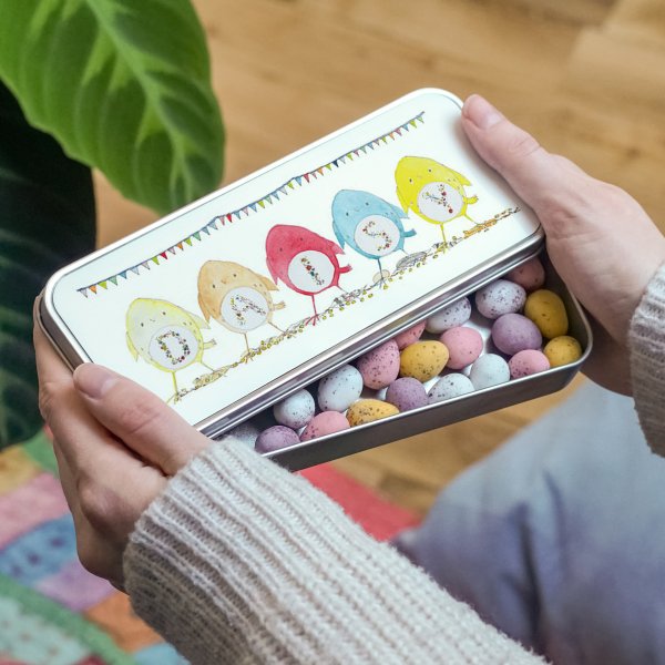 Easter tin filled with mini eggs with rainbow chick illustrations